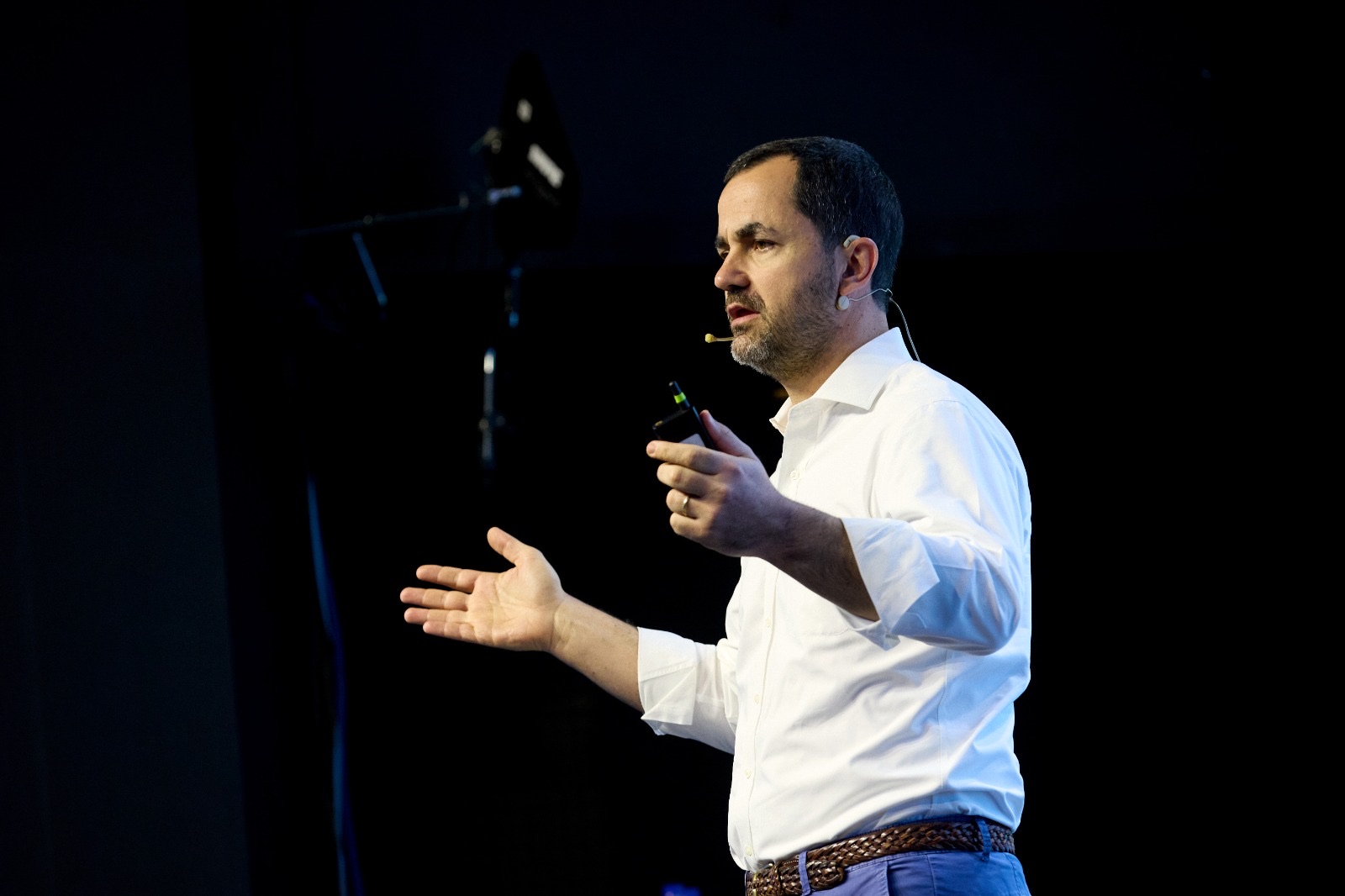 Marcelo Lima falando no palco, com microfone de cabeça